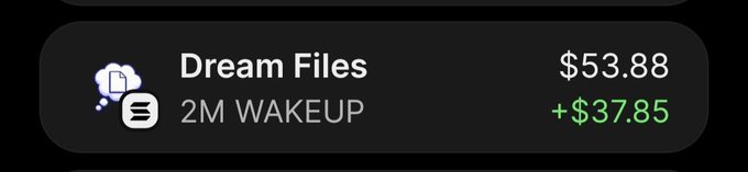 A dark mobile UI notification or transaction screen showing 'Dream Files' with '2M WAKEUP' at $53.88, displaying a positive change of +$37.85 in green text.