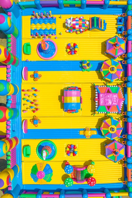 An overhead view of a brightly colored inflatable bouncy castle filled with various play structures.