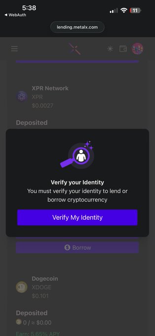 The image shows a cell phone screen with an error message displayed, possibly due to a buggy app or system issue. The text "Verify My Identity" suggests that the user needs to verify their identity for some reason. The background of the image is black, which contrasts with the purple and green elements in the foreground.