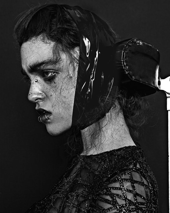 A black-and-white portrait of a person in profile wearing a glossy black latex hood, with smudged makeup and a lip piercing, paired with the post "Gm guys" for a dark, edgy aesthetic contrast.