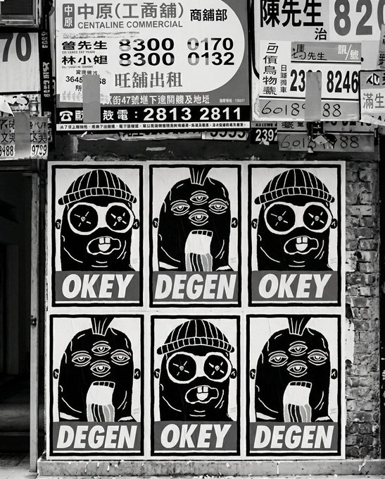 A black-and-white street scene shows a wall covered with Chinese commercial signs (including 'CENTALINE COMMERCIAL') and phone numbers above six stylized posters of figures with three eyes wearing hats, labeled alternately 'OKEY' and 'DEGEN'.