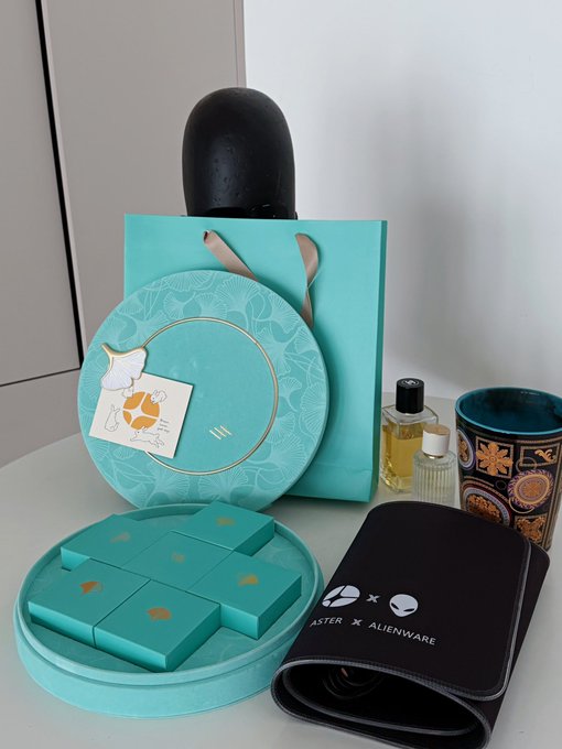 A Tiffany & Co. branded gift set in teal packaging, containing an Alienware x Blaster collaboration pouch and various luxury items.