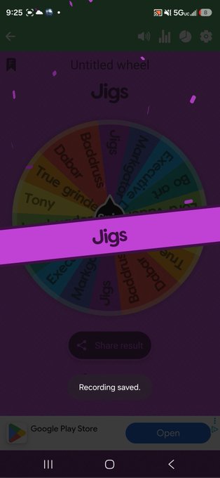 The image shows a phone screen displaying a purple wheel game app, which has been won by someone named Jigs. The app is called "Jigs" and was posted on Google Play Store. A message congratulating Jigs for winning the 100 dollars in reposting the space and being there that night can be seen below the title of the app.