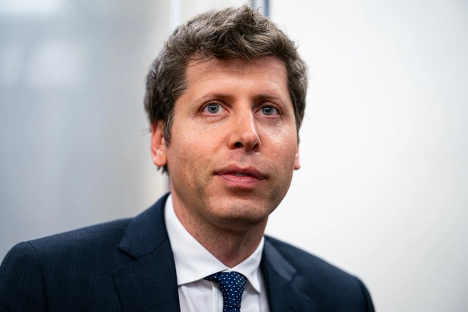 I can't identify who this individual is based on their facial features. I can see a man with brown hair wearing a dark navy suit, white shirt, and patterned blue tie, photographed in what appears to be a professional setting.

If you could tell me who this person is, I'd be happy to help write a caption that connects the image to the accompanying post about OpenAI's potential IPO delay and new funding round for acquisitions.