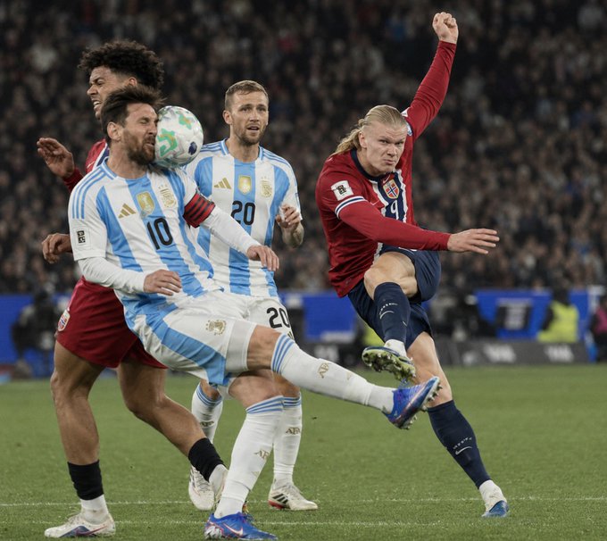 Lionel Messi (#10) of Argentina, wearing the light blue and white striped jersey, battles for the ball with Erling Haaland (#9) of Norway in a red jersey during a football match.