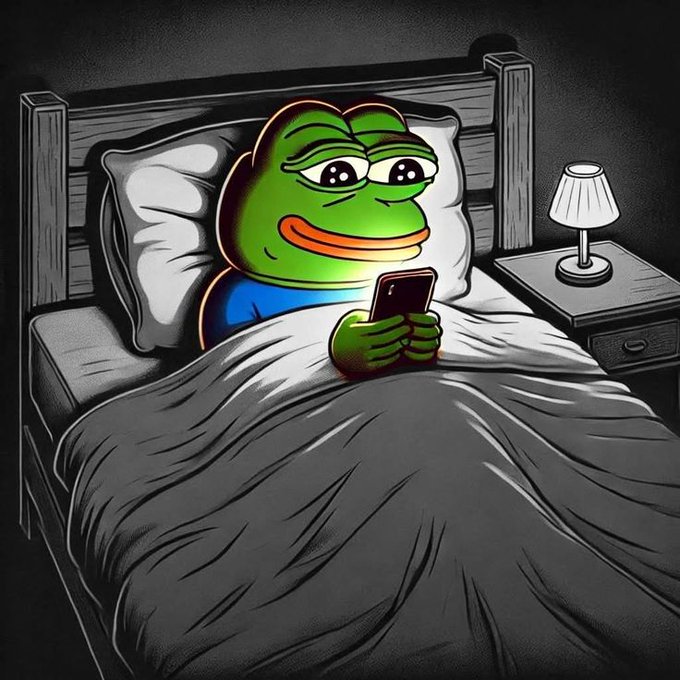 A digital illustration of a green Pepe the Frog character lying in a bed with a blanket pulled up, looking at a smartphone with a content expression, with a lamp on the bedside table in the background.