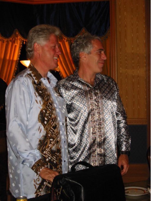 Two men wearing shiny silver/blue traditional shirts standing next to each other at what appears to be an indoor event.