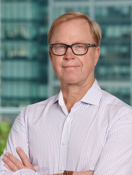 Jurrien Timmer, Fidelity's Director of Global Macro, stands confidently with arms crossed against a glass office building backdrop, illustrating the accompanying text about his new analysis positioning bitcoin alongside traditional diversifiers like gold and commodities.