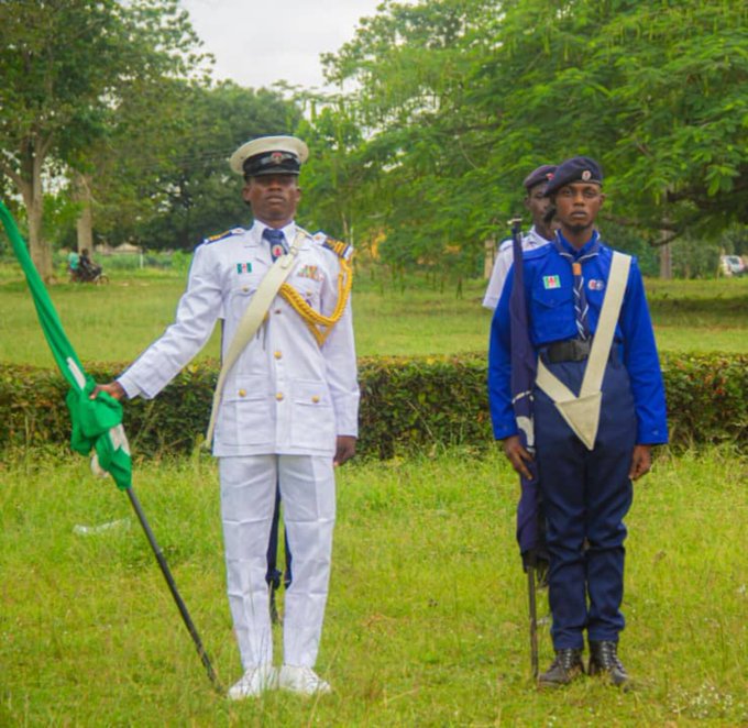 A naval officer in a crisp white dress uniform stands at attention holding the Nigerian flag, accompanied by cadets in blue uniforms holding rifles, symbolizing disciplined leadership and service. The image visually reinforces the post's message about a captain's true measure of success being completed missions rather than empty talk—aligning with the disciplined, mission-focused ethos that EthraShip brings to bridging blockchain with real-world industries.