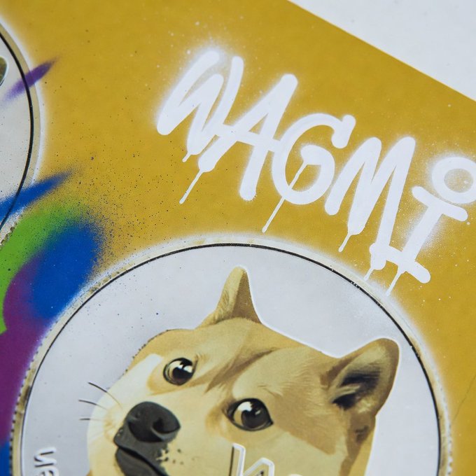The image features a close-up of a coin with a brown dog face drawn on it, giving the impression that the dog is looking at the camera. The background appears to be yellow, which contrasts with the white text "WAGM" written in black letters above and below the coin. This combination of colors creates an interesting visual effect, making the dog's face stand out prominently against the yellow background.