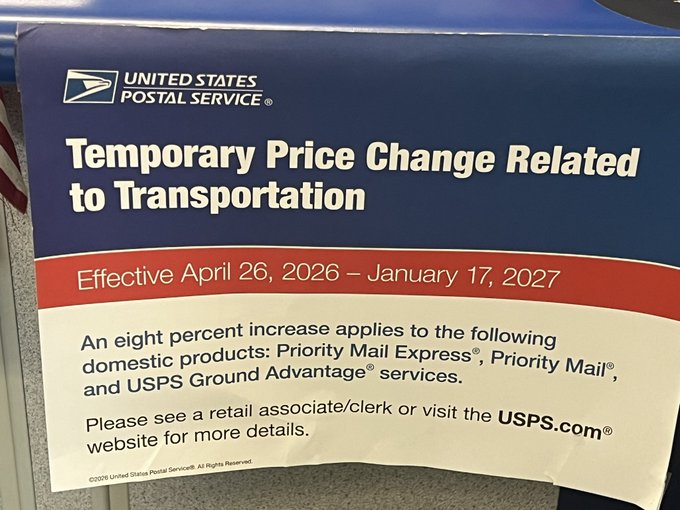 A United States Postal Service sign announces a temporary 8% price increase on Priority Mail Express, Priority Mail, and USPS Ground Advantage services, effective April 26, 2026 through January 17, 2027. The post questions the use of "temporary" while noting the increase exceeds typical inflation rates, suggesting skepticism about the duration and justification of the hike.