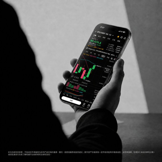 A black and white photograph shows a person holding a smartphone displaying a cryptocurrency trading app with candlestick charts, with text visible at the bottom indicating it's for illustrative purposes only.