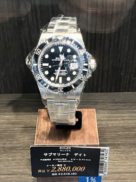 A Rolex Submariner Date watch is displayed on a stand with a Japanese price tag of ¥2,880,000, contrasting the luxury timepiece's high value with the post's somber caption about a market crash ("crash implied").