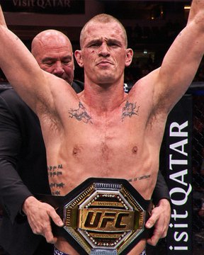 A shirtless UFC fighter wearing a championship belt with the "UFC" logo and "VISIT QATAR" visible in the background stands triumphantly with his arms raised, celebrating a victory—a moment tied to a $76.6K bet placed on Ian Garry to win against Islam Makhachev tonight with a $326,739 payout via Polymarket.