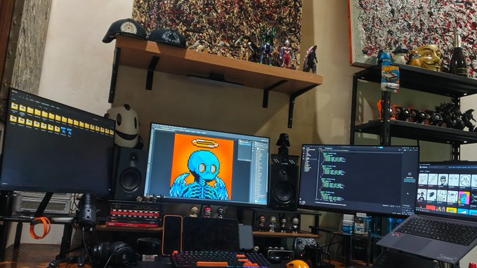 A multi-monitor gaming/streaming setup is shown with a central screen displaying a skeleton artwork, flanked by side monitors showing file directories and other content, with figurines and collectibles displayed on shelves above.