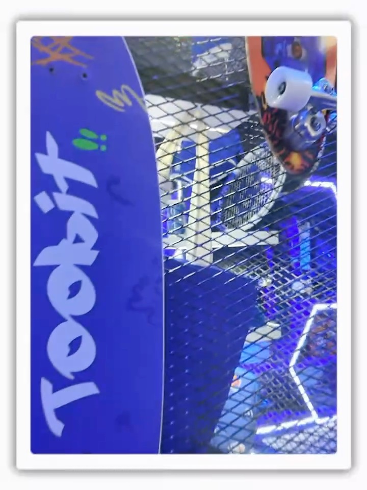 A blue Tostixx vending machine or display with items visible inside the metal cage structure.