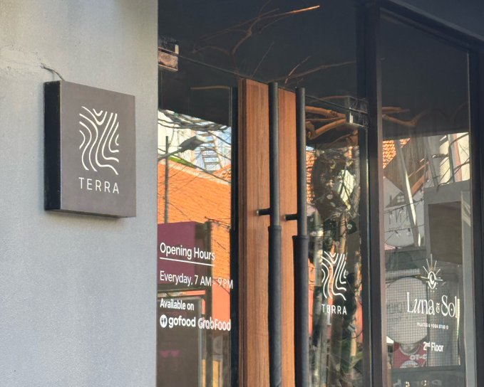 The image shows a restaurant called Terra, which has an opening hour sign displayed above its glass doors. The name "Terra" is written in white letters on the building's exterior. Below the sign, there are two black doors with wooden handles that lead inside the establishment. A window can be seen through one of these doors, and another window is visible at the top right corner of the image.

The post also mentions a website called terra.com, which might provide information about the restaurant or related services. The text in the image suggests that there could be some sort of connection between the restaurant's name and the crypto market crash, although it is not clear how these two elements are related.