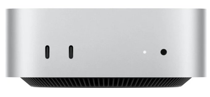 The image shows a small, silver Mac mini computer with two USB ports at the bottom of its back panel. The computer has a sleek design that suggests it's a high-quality device. The background appears to be a light brown color, which contrasts nicely with the silver of the computer and makes it stand out.