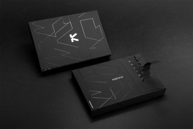 Two matte black packaging boxes for 'KASTXYZ' featuring minimalist line art designs and a stylized 'K' logo on a dark surface.