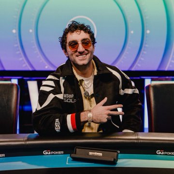A smiling man with curly hair and round sunglasses, wearing a black 'MSOP GOLD' jacket, sits at a poker table with 'GGPOKER' branding on the rail.
