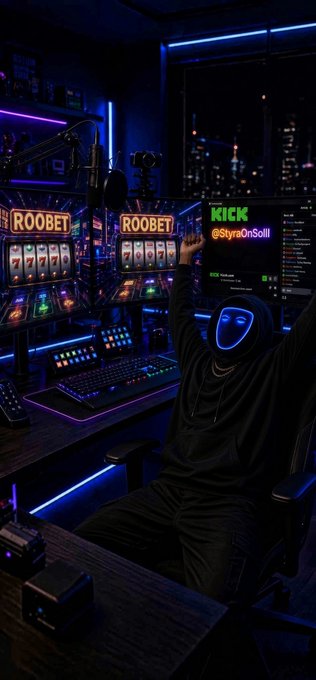 A person in a black hoodie and glowing blue mask sits at a futuristic, neon-lit gambling/slot machine setup with raised arms, surrounded by screens displaying 'ROOBET' and 'KICK' branding.