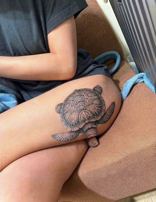 A detailed black-and-grey sea turtle tattoo rests on a person's thigh, cleverly positioned so the turtle's tail appears to sit right on the leg like a freshly laid turd, humorously matching the "Poop" caption.