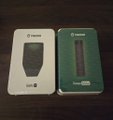 Two small product boxes, possibly wireless earbuds or audio devices, sit side by side on a dark wooden surface.