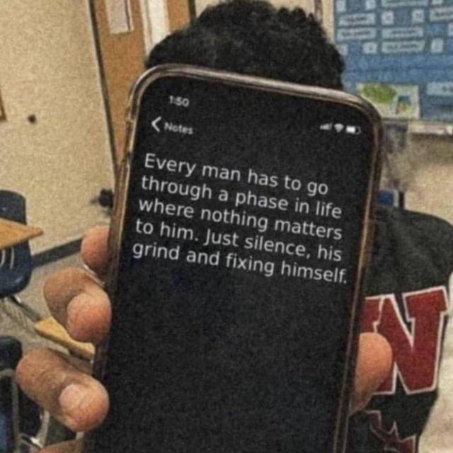 A person holds up an iPhone displaying a Notes app entry that reads, "Every man has to go through a phase in life where nothing matters to him. Just silence, his grind and fixing himself." The image ties into the post's theme of "the grind" by showing a motivational note about embracing solitude, silence, and self-improvement.