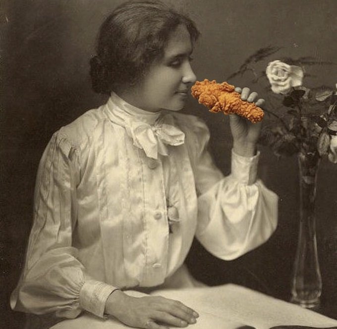 A vintage sepia photograph of a woman in an early 20th-century white blouse holding a large orange marigold to her nose to smell it, paired with a tumbler of roses. The meme humorously suggests Hellen Keller, who famously relied on her sense of smell, would be "bullish" on the slang term "$tendies" (gains/profits) just as the woman is appreciating the flower's scent.