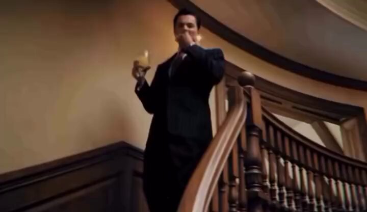 In the image, a man dressed in a suit stands on a staircase holding a glass of wine, likely enjoying his time as he ascends. The post suggests that this man has just won money at an amusement park through a game called "How bro acts after turning $50 into $51.69 with 669 trades", and is now boasting about his win by buying more tickets to continue playing. The focus of the image is on the man's actions, as he stands in front of the staircase holding a glass of wine and a ticket, possibly celebrating his victory or contemplating what to do next with his winnings.