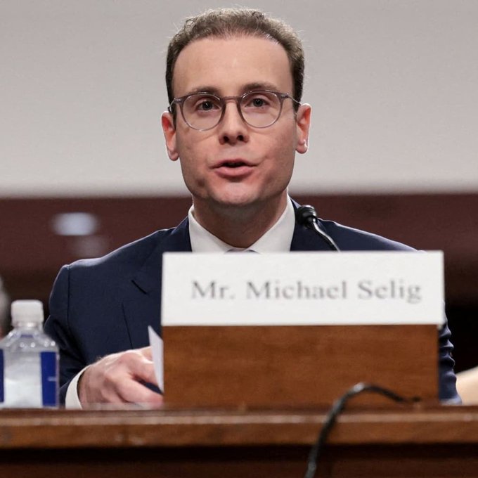 CFTC Chair Michael Selig speaks at a podium with a nameplate reading "Mr. Michael Selig," following news that he has directed staff to draft crypto market structure rules if the CLARITY Act fails to pass.