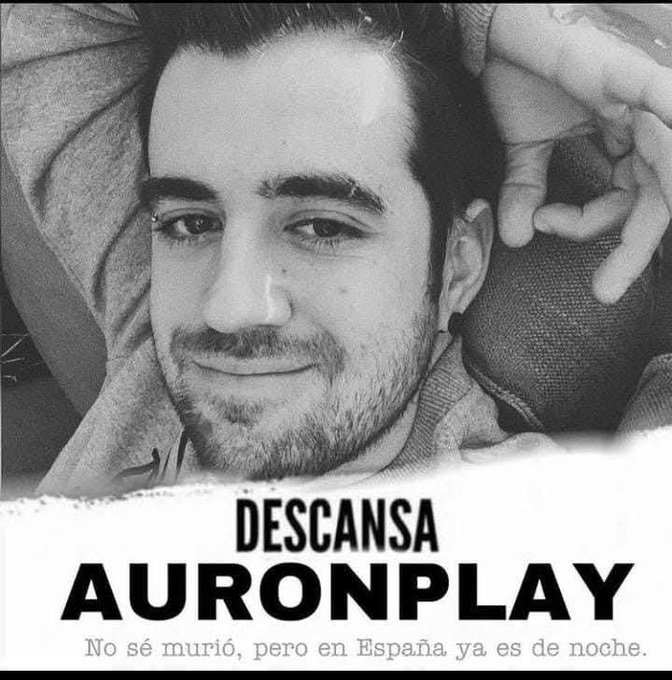 A black-and-white meme photo shows a young bearded man smiling slightly, with text reading "DESCANSA AURONPLAY" and the Spanish caption "No sé murió, pero en España ya es de noche." (a play on the phrase "I don't know if he died, but in Spain it's already night"—a common Spanish internet joke about Auronplay, a popular Spanish YouTuber).