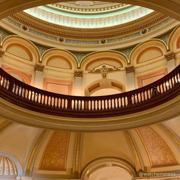 The image shows the ornate interior of a domed government building, likely a state capitol, with decorative architectural details including a central rotunda, gilded balconies, and intricate ceiling patterns. The accompanying text suggests the photo represents the political sphere where a crypto-aligned PAC is spending $1 million to influence Michigan's Democratic primary against Rep. Shri Thanedar, highlighting the intersection of cryptocurrency interests and traditional political venues.