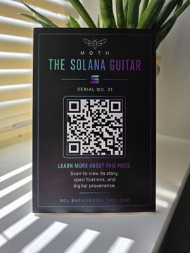 A black plaque labeled 'THE SOLANA GUITAR - SERIAL NO. 31' features a QR code and instructs to scan for item details from SOL.BACKLINEGUITARS.COM.