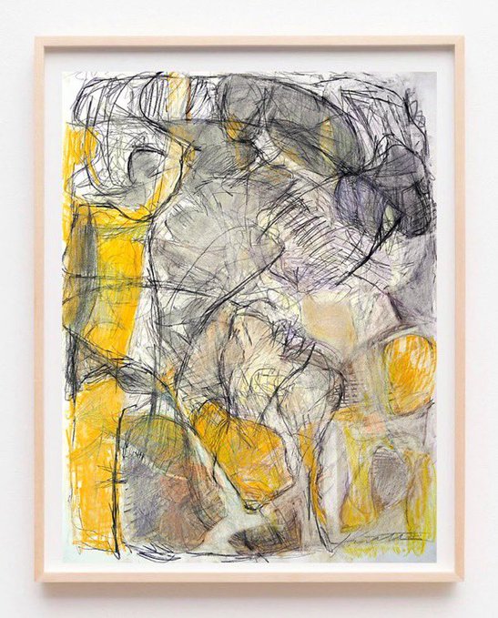 An abstract mixed-media artwork featuring loose charcoal or graphite sketching layered with vibrant yellow watercolor washes, displayed in a light wood frame against a white wall.