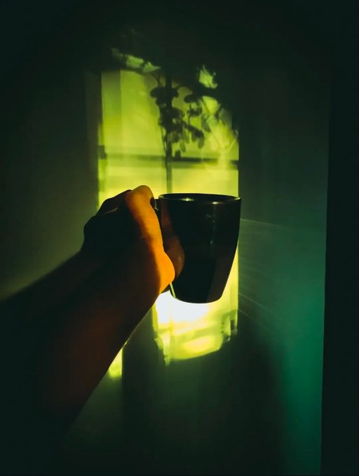 A hand holding a dark mug is silhouetted against a window glowing with warm golden-green light and the shadowy outline of a plant. The moody, contemplative atmosphere pairs with the post's message of community and growth, symbolizing a quiet moment of reflection on the strengthening connections within the Web3 space.