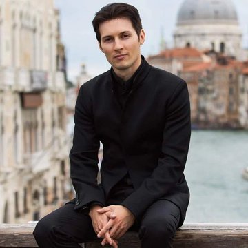 A man with dark hair wearing a black suit sits thoughtfully on a wooden railing, with Venice's iconic domed architecture and canal visible in the background. The accompanying quote about Bitcoin's potential rise to $1,000,000 aligns with the image's contemplative mood, symbolizing forward-thinking financial philosophy.