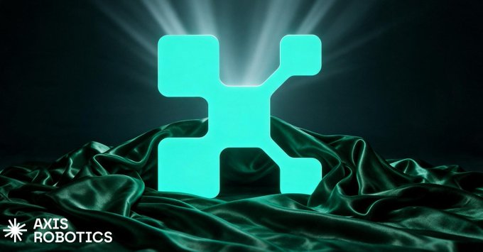 The image features a glowing turquoise robotic/tech-themed logo centered against a dark background with green satin fabric draping below it, accompanied by the "AXIS ROBOTICS" branding in the bottom-left corner—visually representing the Axis Robotics browser-based platform mentioned in the post, where users can control simulated robots for real-world AI training data.