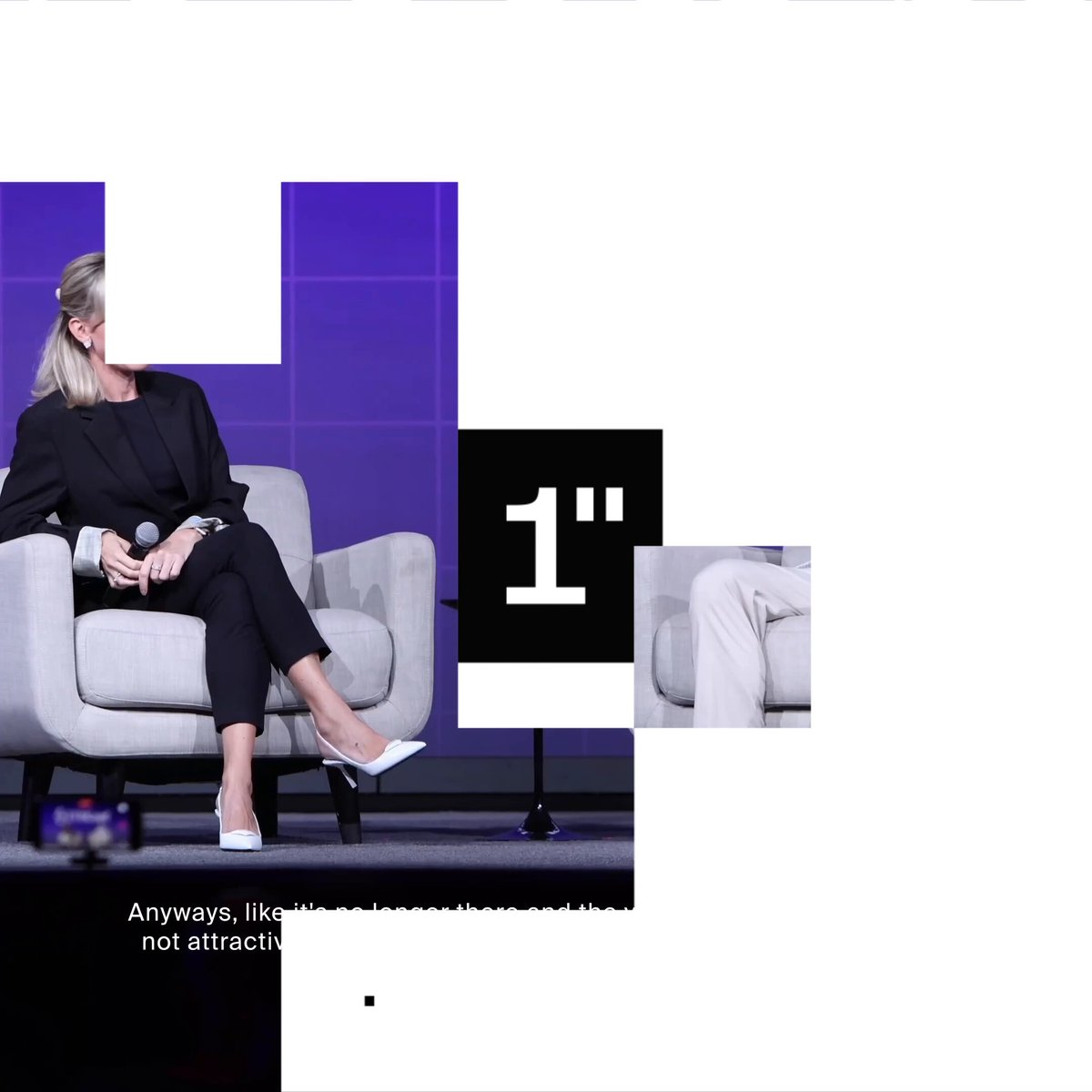A woman sits comfortably in a gray chair, facing away from the camera while holding a microphone at a conference stage. The background features purple squares with the text "1" printed across them, and additional text below reading "ways like DeFi' that are not attractive enough for complexity".