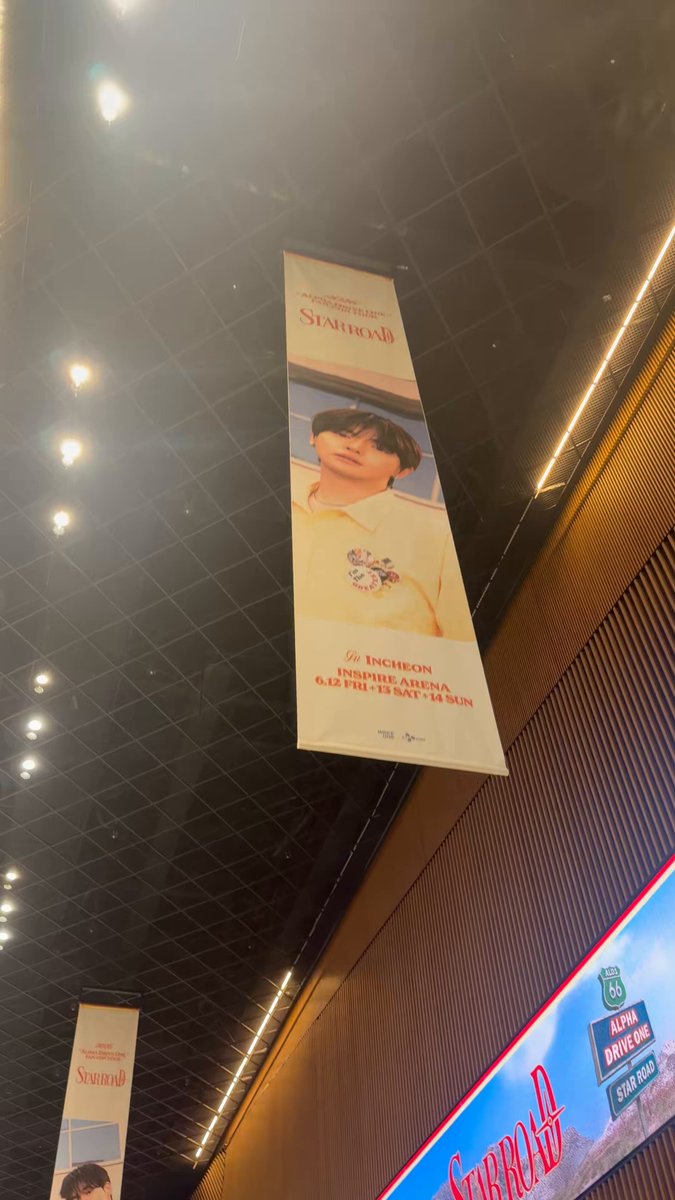 The image features a banner hanging from an overhead light fixture, which has a picture of a person on it. The banner also contains text that reads "and so.. we are in!!! #ALPHADRIVEONE #ALD1 #알파드라이브원". This suggests that the image is related to an advertisement or promotional campaign, possibly for a product or service. The banner's position and the presence of the person on it indicate that this might be taking place in a public space such as a mall or shopping center where people can easily see the advertisement while they are walking around.

The post also mentions "ALPHADRIVEONE #ALD1 #알파드라이브원". This could be an identifier for the banner, possibly to help locate it or to provide more information about its content. The image's focus on the person and the text suggests that this is a promotional campaign aimed at attracting attention and generating interest in a product or service.
