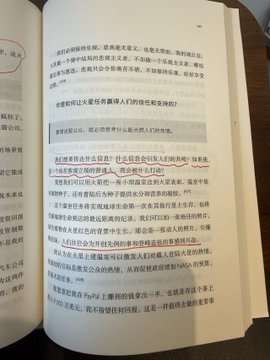 An open Chinese-language book page with highlighted passages and handwritten annotations in the margins, resting on a wooden surface.