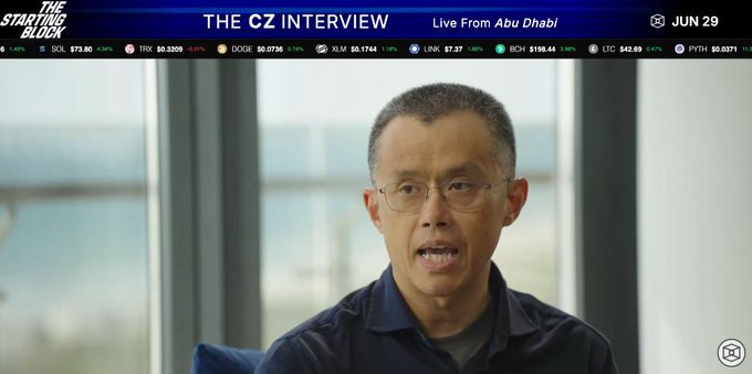 A man appears in an interview titled "THE CZ INTERVIEW" with "The Starting Block" logo, broadcast "Live From Abu Dhabi" on "JUN 29." The screen also displays cryptocurrency ticker information including SOL, TRX, DOGE, XLM, LINK, BCH, LTC, and PYTH, aligning with the accompanying post about CZ's (Changpeng Zhao) interview with The Block following his transition from Binance CEO.