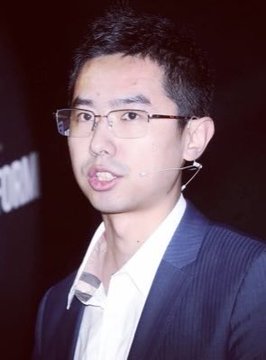 A young Asian man with short black hair, rectangular black-framed glasses, and a flesh-colored earpiece microphone is shown speaking, dressed in a dark navy pinstripe suit jacket over a crisp white collared shirt. He appears to be on stage delivering a presentation, likely as a tech entrepreneur or blockchain executive. The image accompanies a breaking news post about Garrett Bullish, who reportedly just closed his entire $58 million short position on Zcash ($ZEC), suffering a $35 million loss on the trade—suggesting the man pictured may be the trader in question facing significant financial repercussions from his bearish bet on the cryptocurrency.
