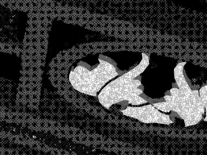 A black and white heavily textured/halftone filtered image showing what appears to be a white ribbon or fabric shape against a dark, speckled background.