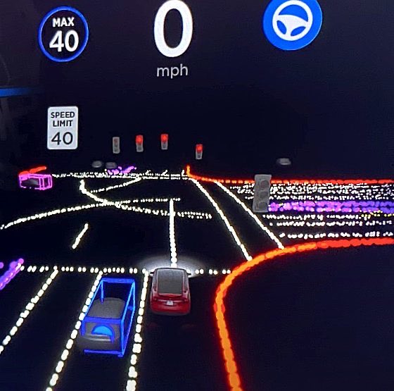 Futuristic car dashboard/AR navigation display showing a speed of 0 mph, a 40 mph speed limit, and a 3D road visualization with lit-up vehicles and lane markings.