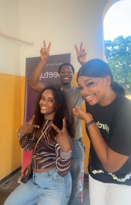 Three young people pose together with peace signs and pointing gestures, smiling in front of a banner that reads "arc" and "nurture" (with "@arc" visible), embodying the joyful community spirit and reach of the @arc community mentioned in the post.