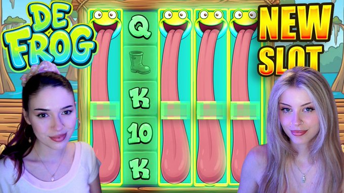 The image features two women standing next to each other, with a large screen behind them displaying an advertisement for a slot machine game called "De Frog". The woman on the left side of the image has blonde hair and is wearing a white shirt, while the woman on the right side has brown hair and is wearing a blue shirt. They are both looking at the screen, which shows a close-up view of the slot machine with its pink tongue sticking out.

The advertisement for the game includes text that reads "De Frog Q K 10", indicating that it's a new slot game called "De Frog". The women seem to be interested in trying this game and are discussing their thoughts on it, possibly sharing their opinions or experiences about the game with each other.