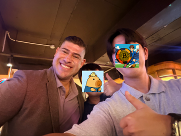 Two men smile for a selfie at what appears to be a KiiChain meetup, with cartoon stickers (including one resembling a Bitcoin symbol) playfully covering their faces, tying into the post's description of the KiiChain project focused on stablecoins, RWA, and on-chain FX orchestration.