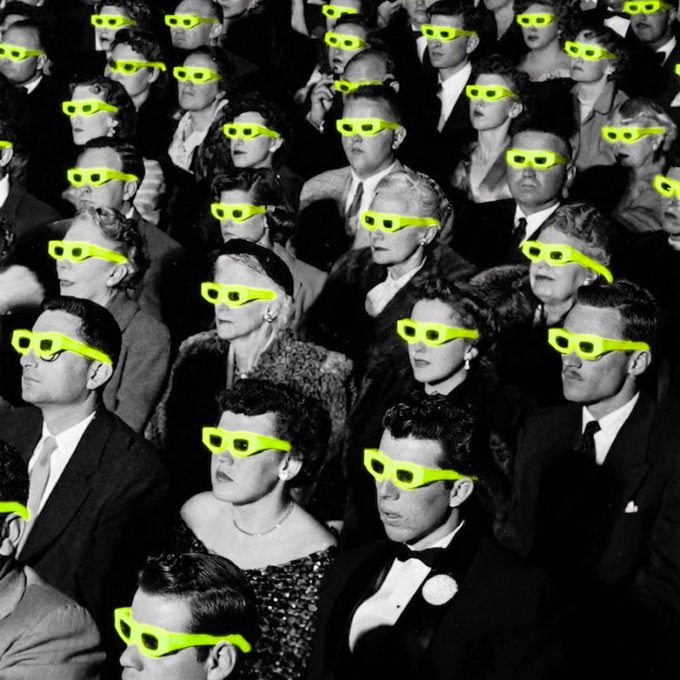 A black and white photo of a vintage movie theater audience, with bright green 3D glasses digitally added to every person in the crowd.