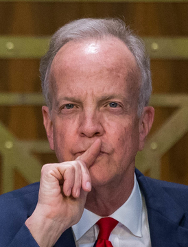 Senator Jerry Moran, a Republican from Kansas, is pictured in a contemplative pose with his hand to his chin, as he announces his opposition to the Clarity Act unless banking concerns are addressed.